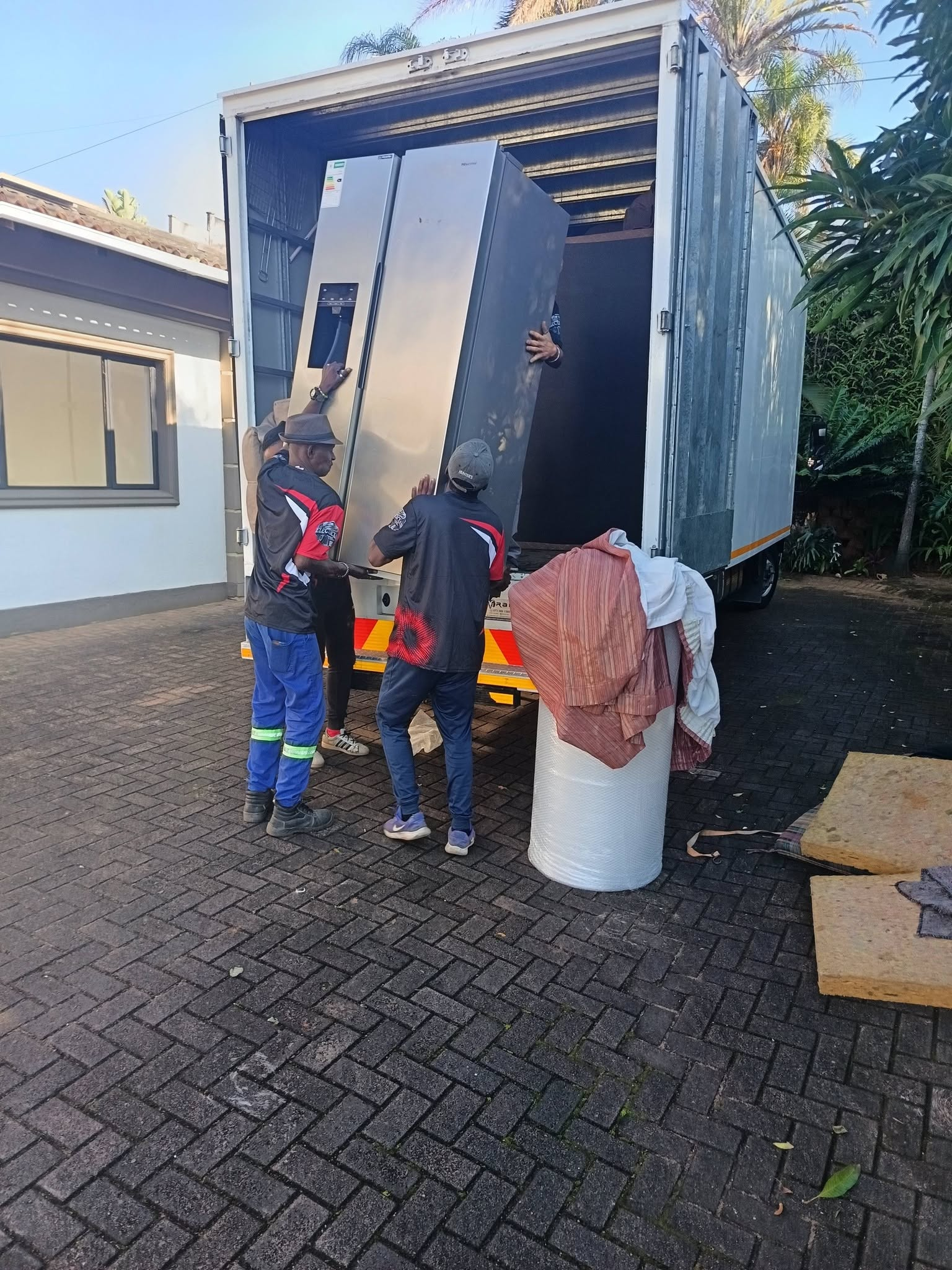 Pro Load Movers team loading a large refrigerator into a moving truck